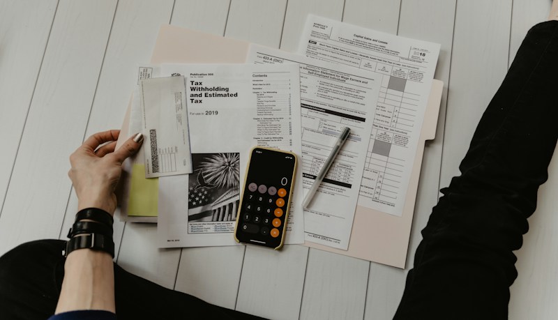 Documentos impositivos, calculadora y lapicera sobre un escritorio