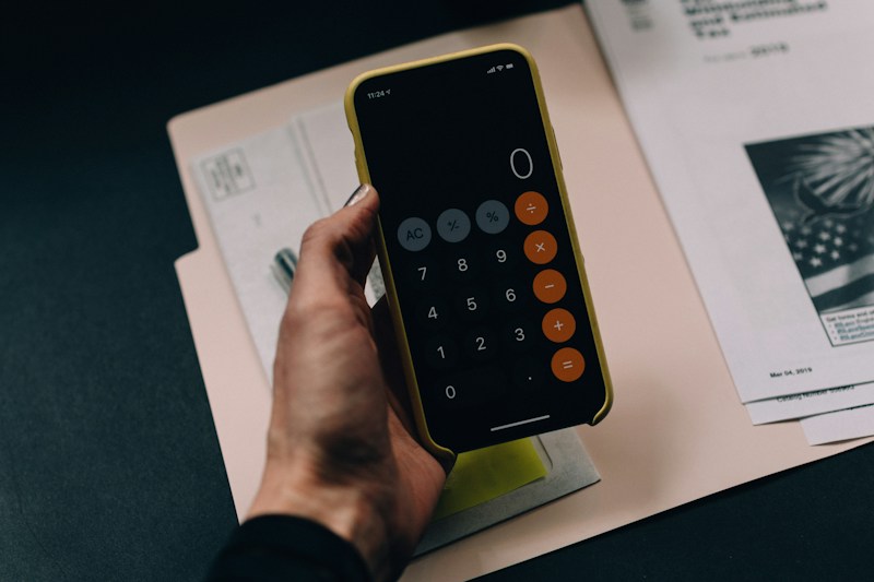 Calculadora en el teléfono junto a documentación impositiva
